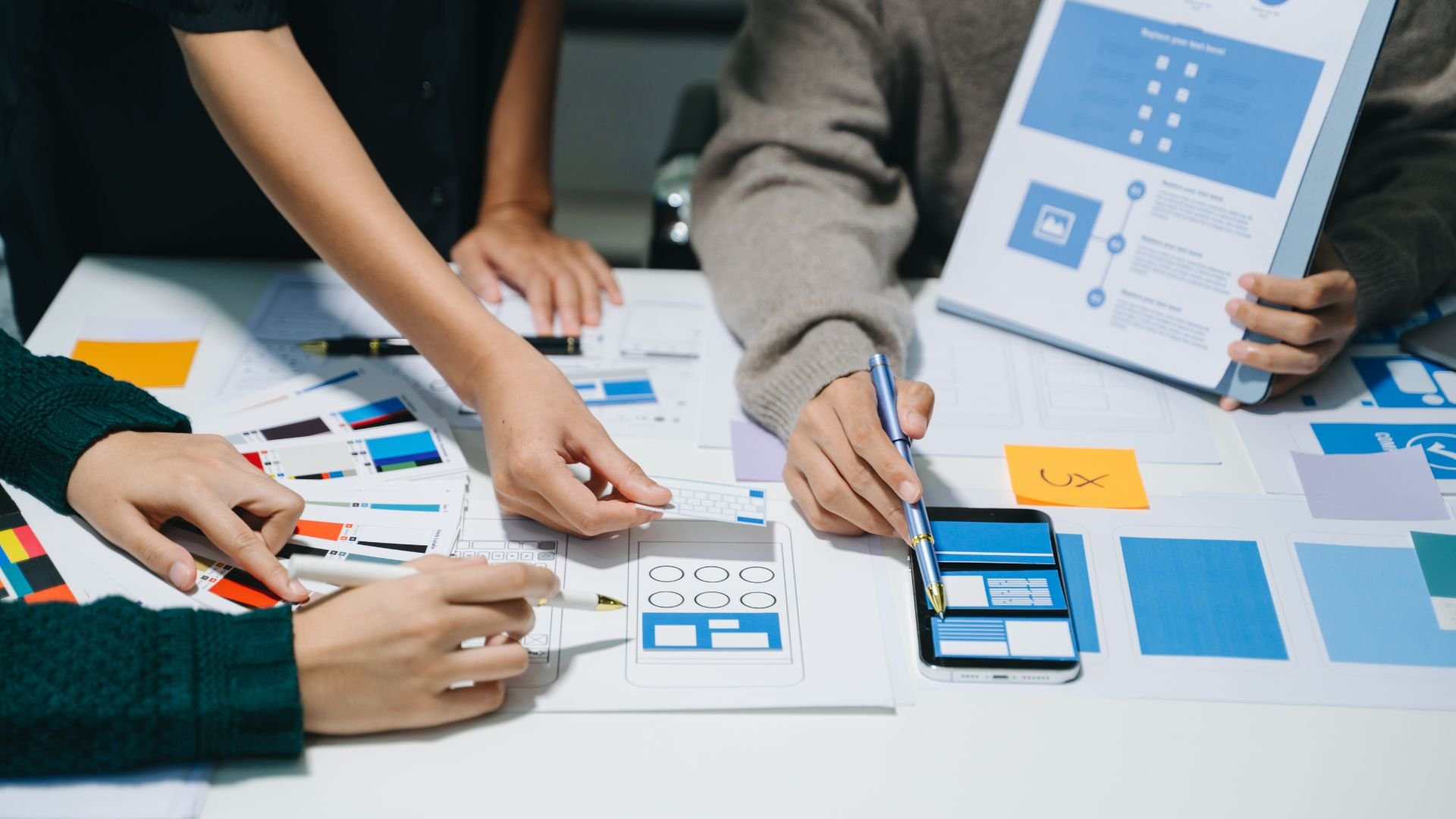 UX designers collaborating on app interface wireframes and color palette